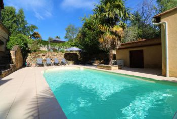 la piscine vue depuis la porte vitrée du salon de la maison 