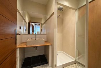 La salle d'eau avec douche et meuble vasque 