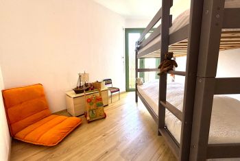 La chambre enfants avec un lit superposé et un espace jeux 